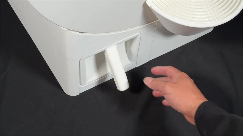 Manual crank handle at the base of the litter box