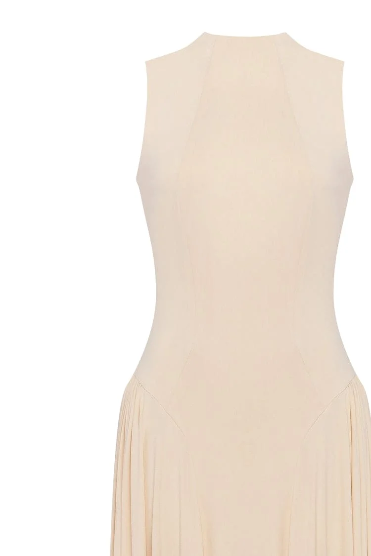 Nude sleeveless mock neck dress with a pleated maxi skirt