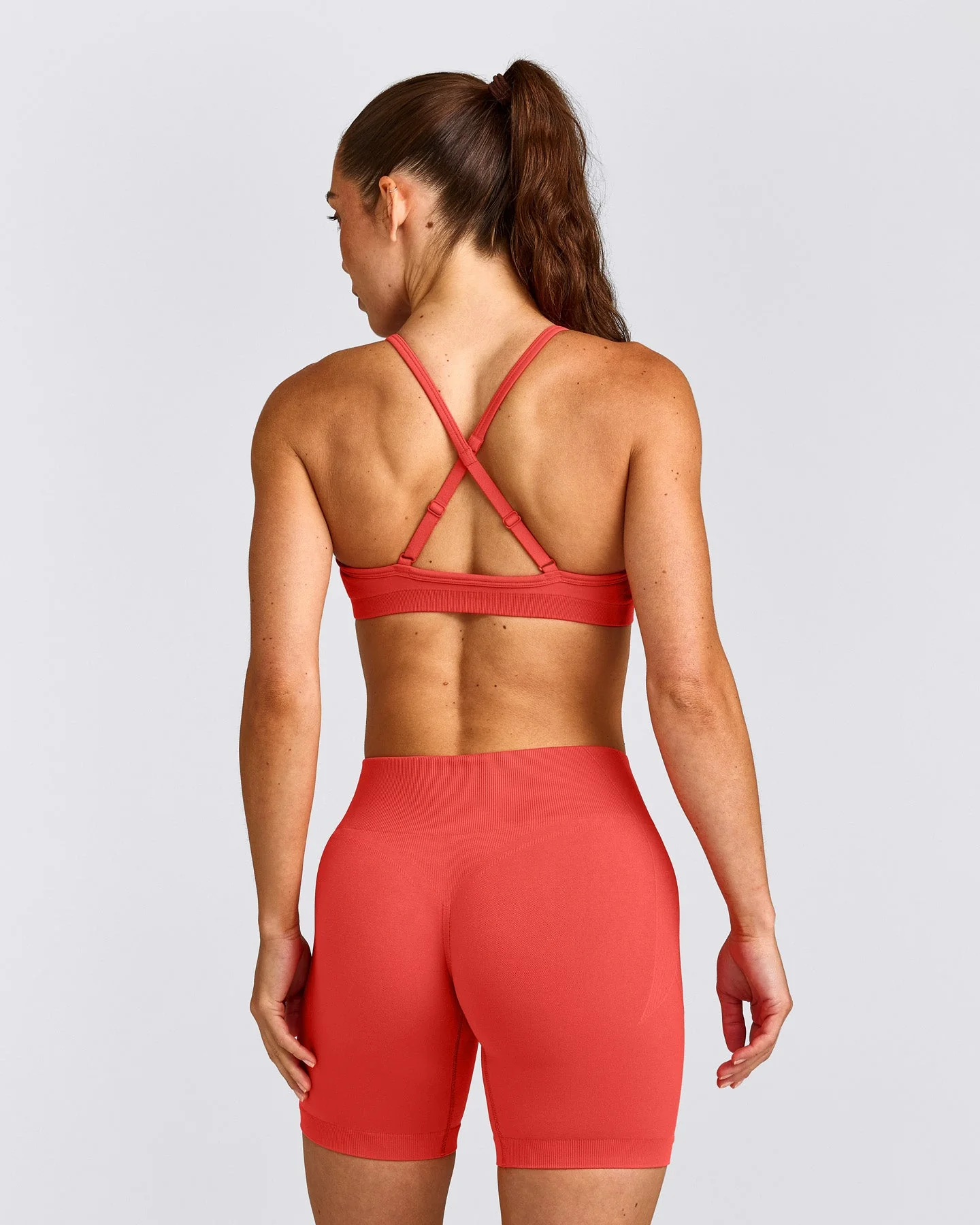 EnhanceLift™ Seamless Strappy Sports Bra with Grey Logo | Dark Charged Coral
