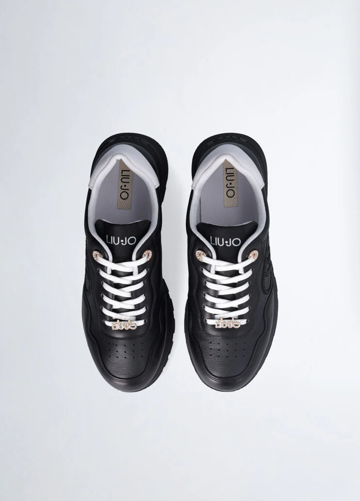 Black leather sneakers with bejewelled logo
