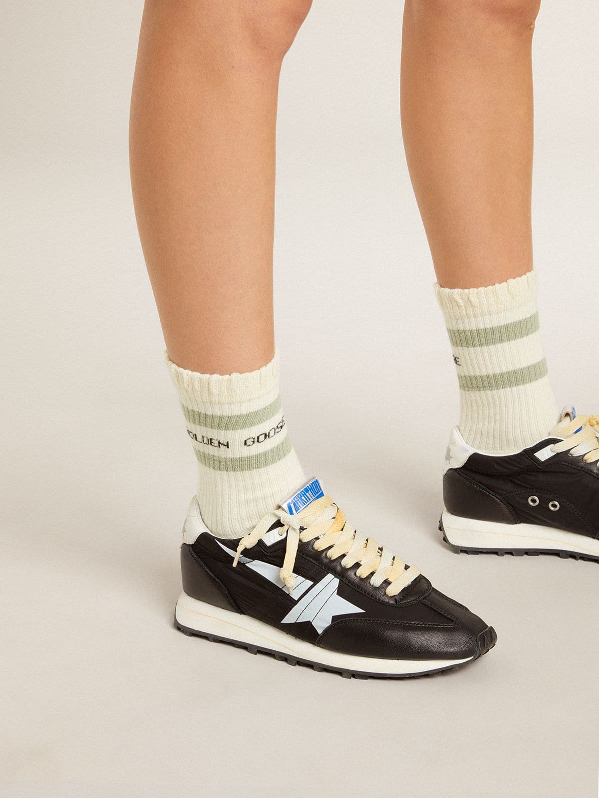 Worn-white socks with distressed details and sage-green stripes