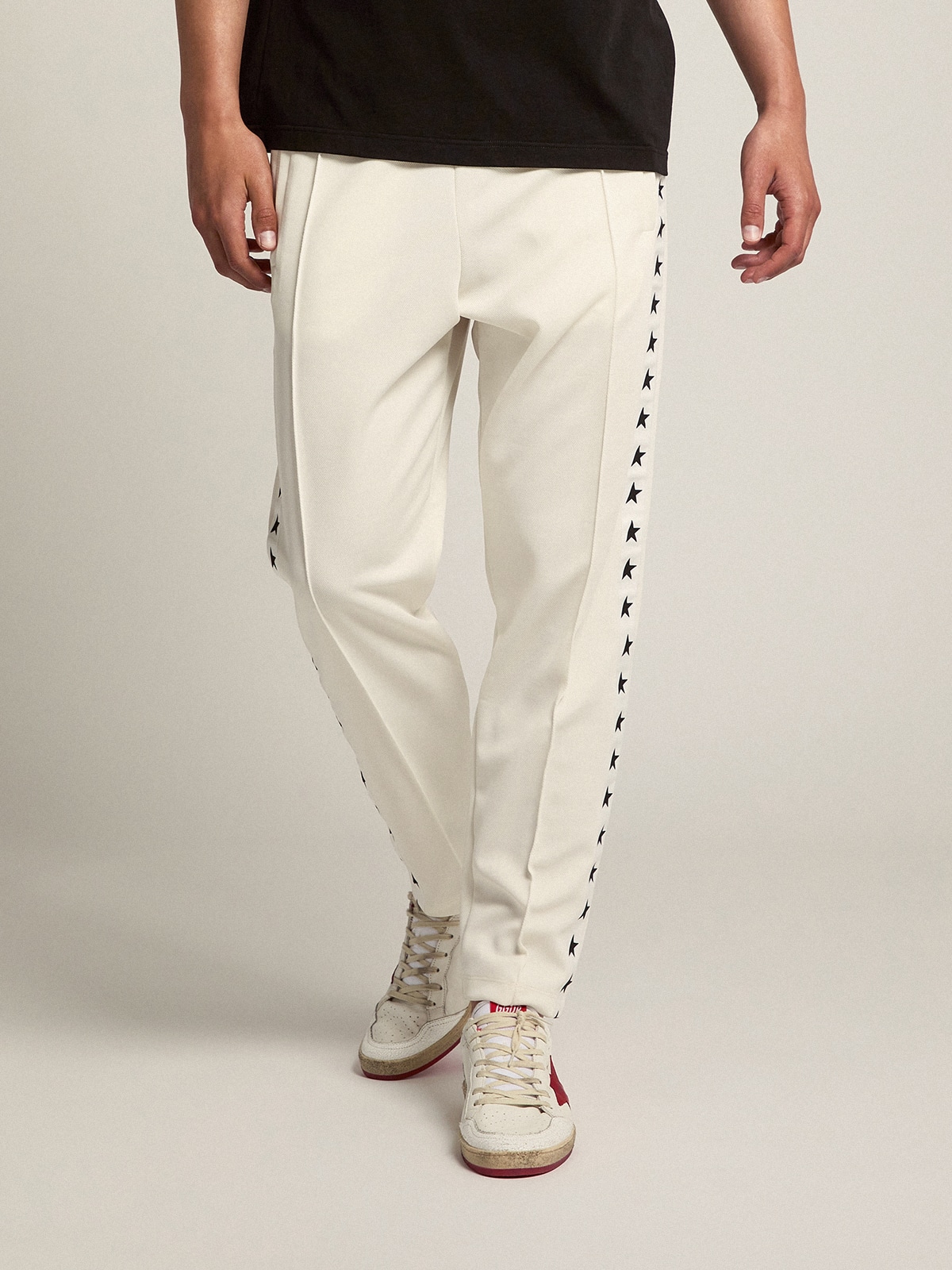 Men's white joggers with black stars on the sides