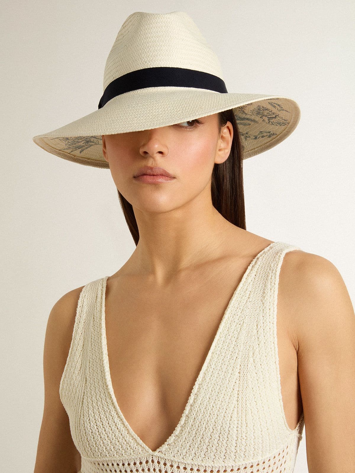 Golden fedora hat in white straw with black ribbon and marine print under the brim