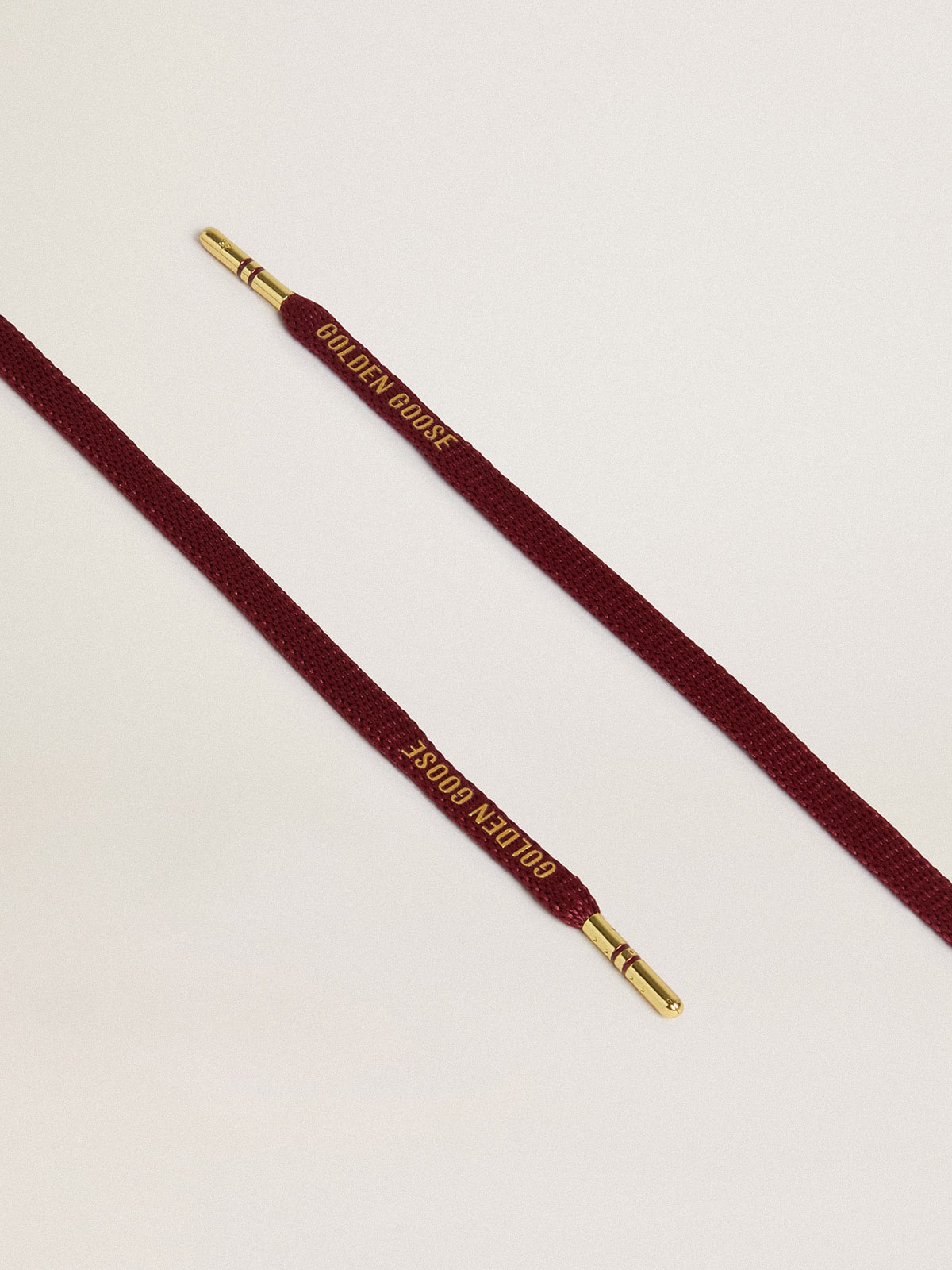 Burgundy cotton laces with contrasting gold-colored logo