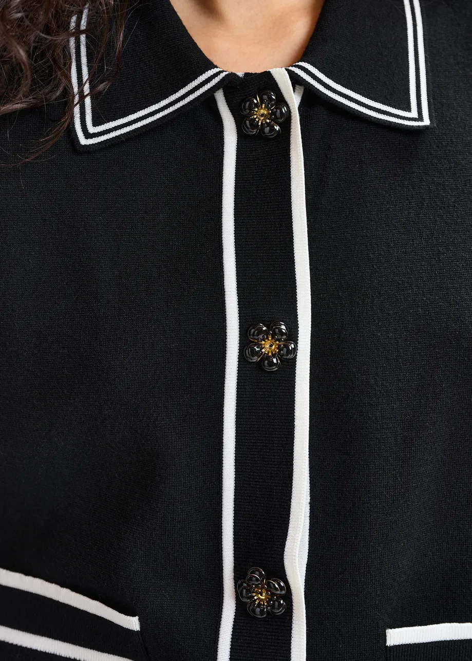 Zwart-witte cardigan met bloemetjesknopen en contrastboord