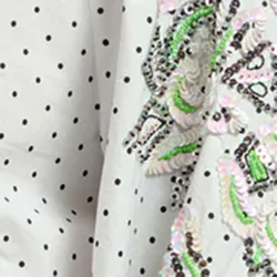 White polka-dotted top with stand-up collar
