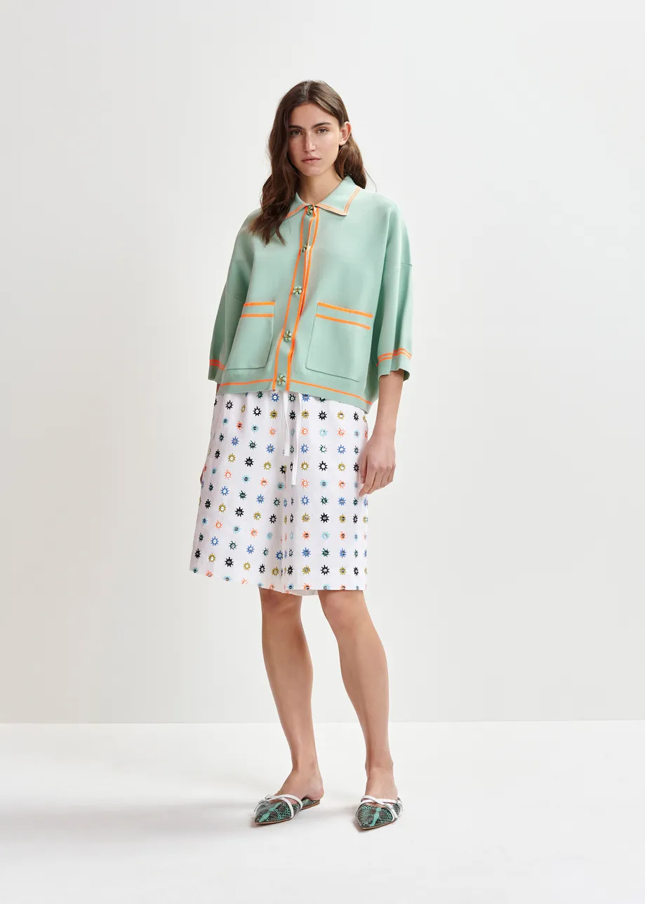 Zwart-witte cardigan met bloemetjesknopen en contrastboord