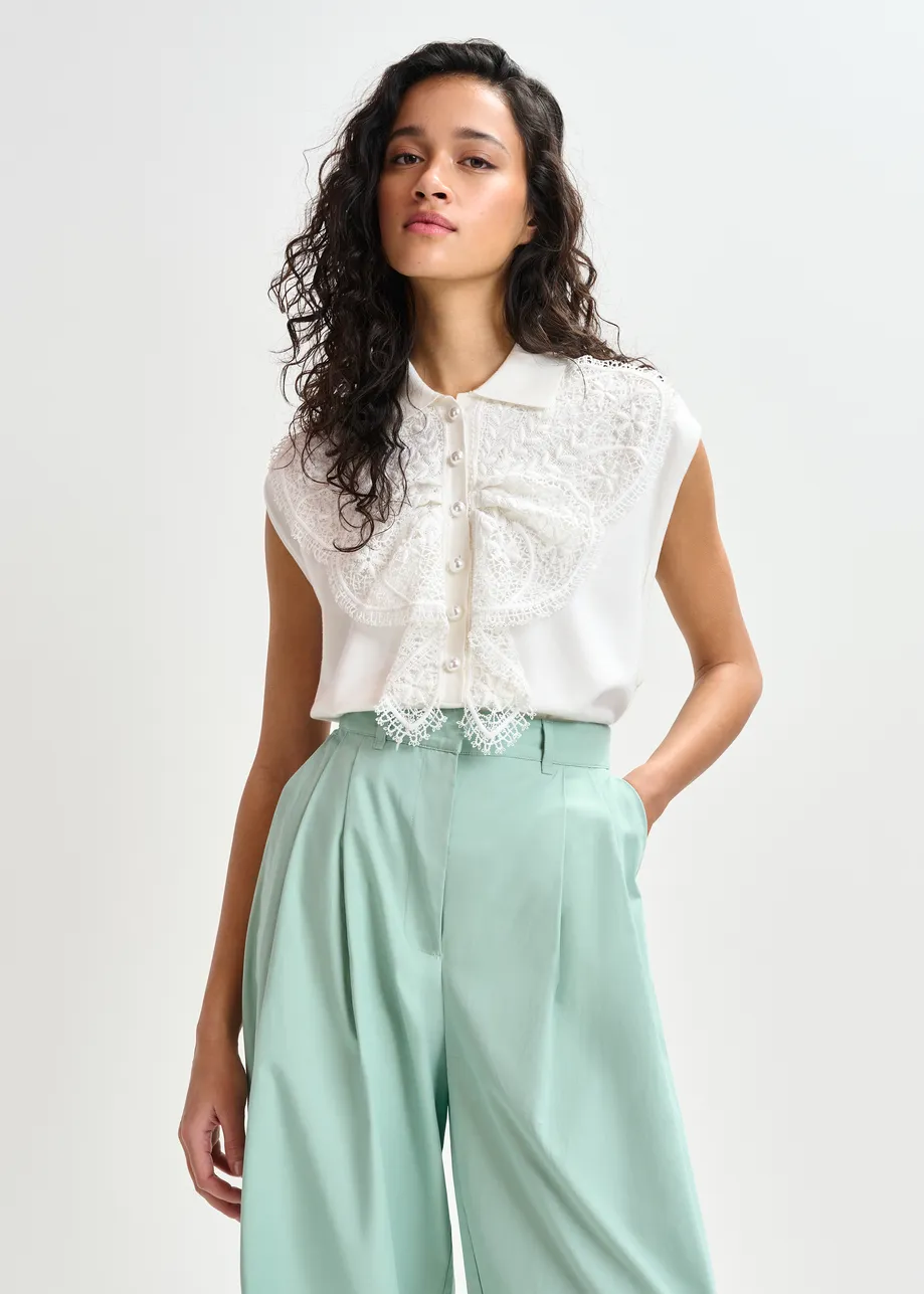 Witte mouwloze polo met kant en parelknopen