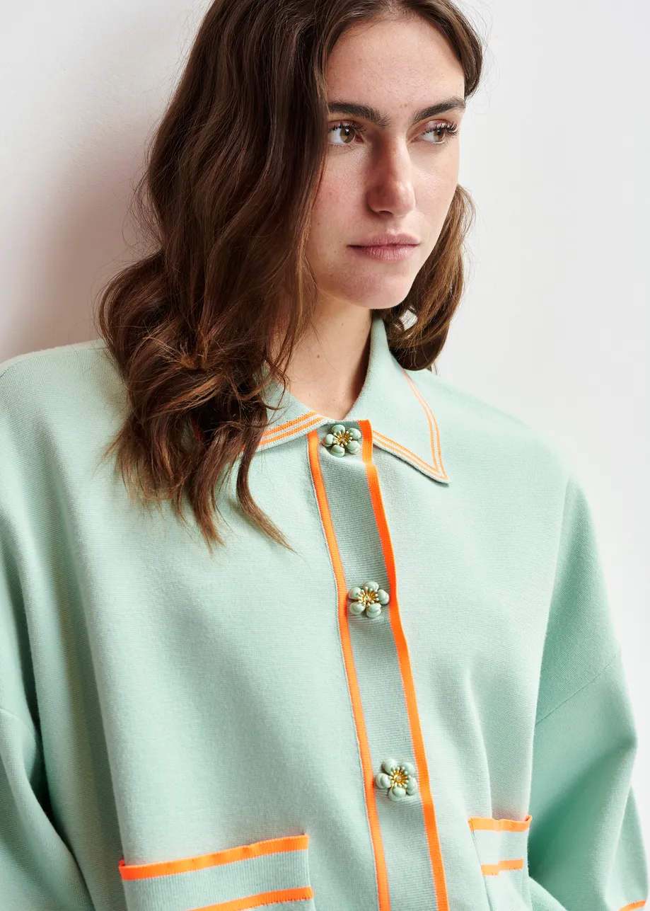 Zwart-witte cardigan met bloemetjesknopen en contrastboord