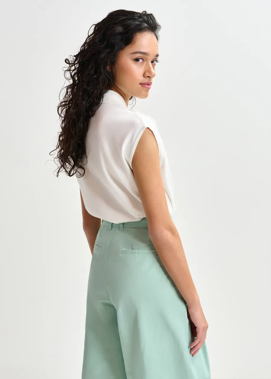 Witte mouwloze polo met kant en parelknopen