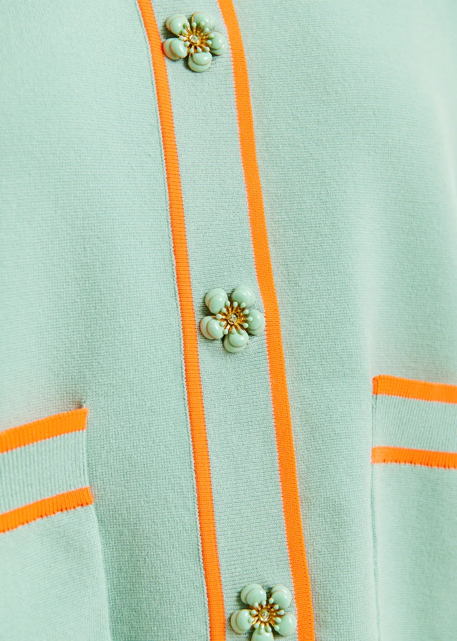 Zwart-witte cardigan met bloemetjesknopen en contrastboord