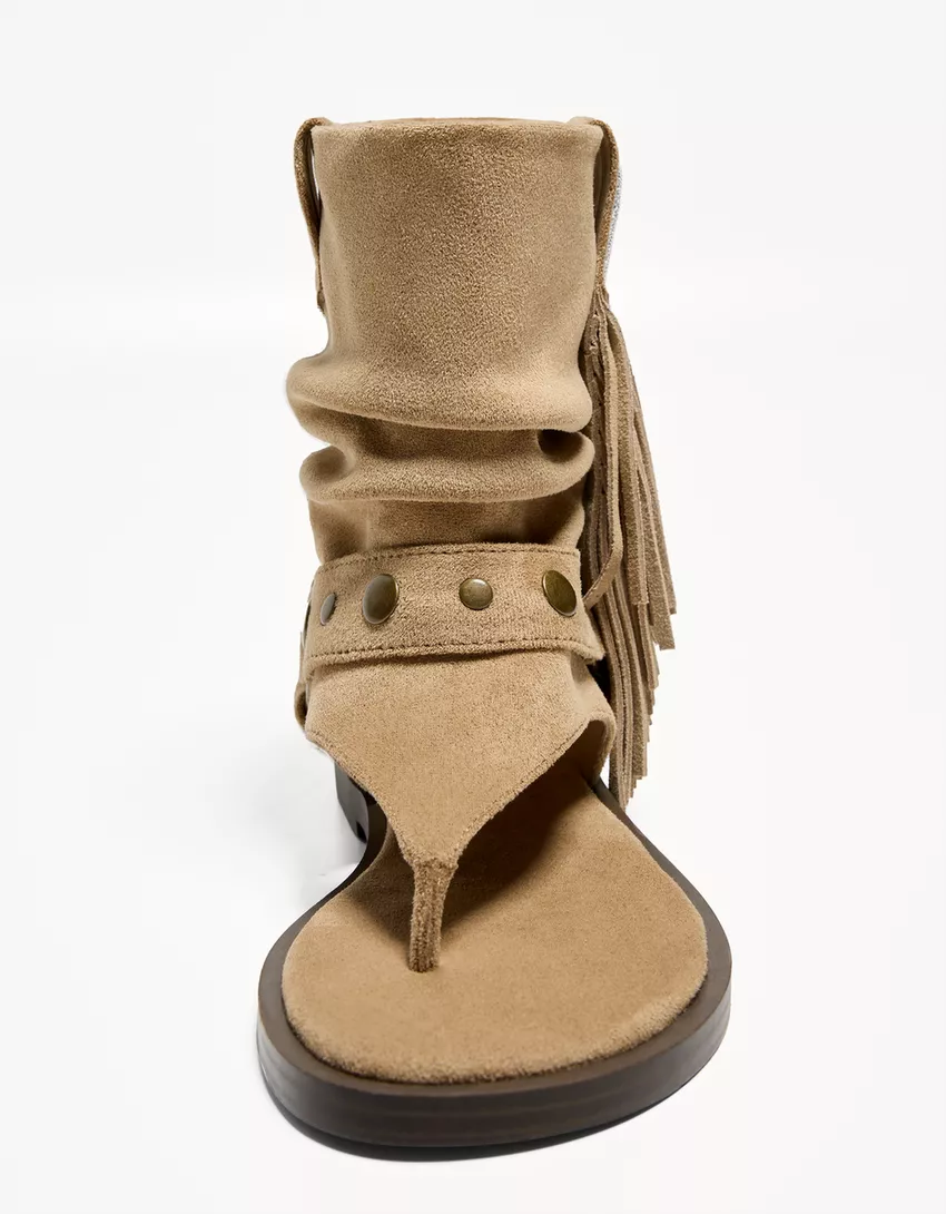 Flat sandals with fringed strap