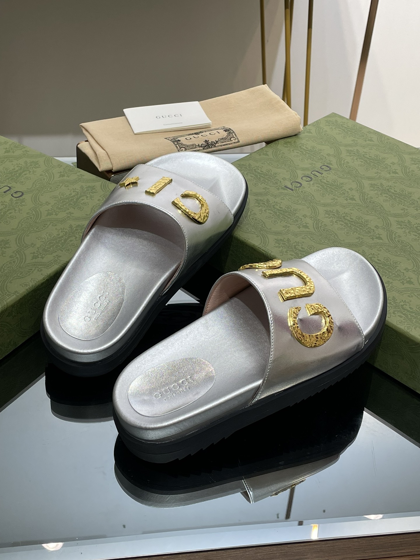Gucci slippers with gold logo lettering buckle