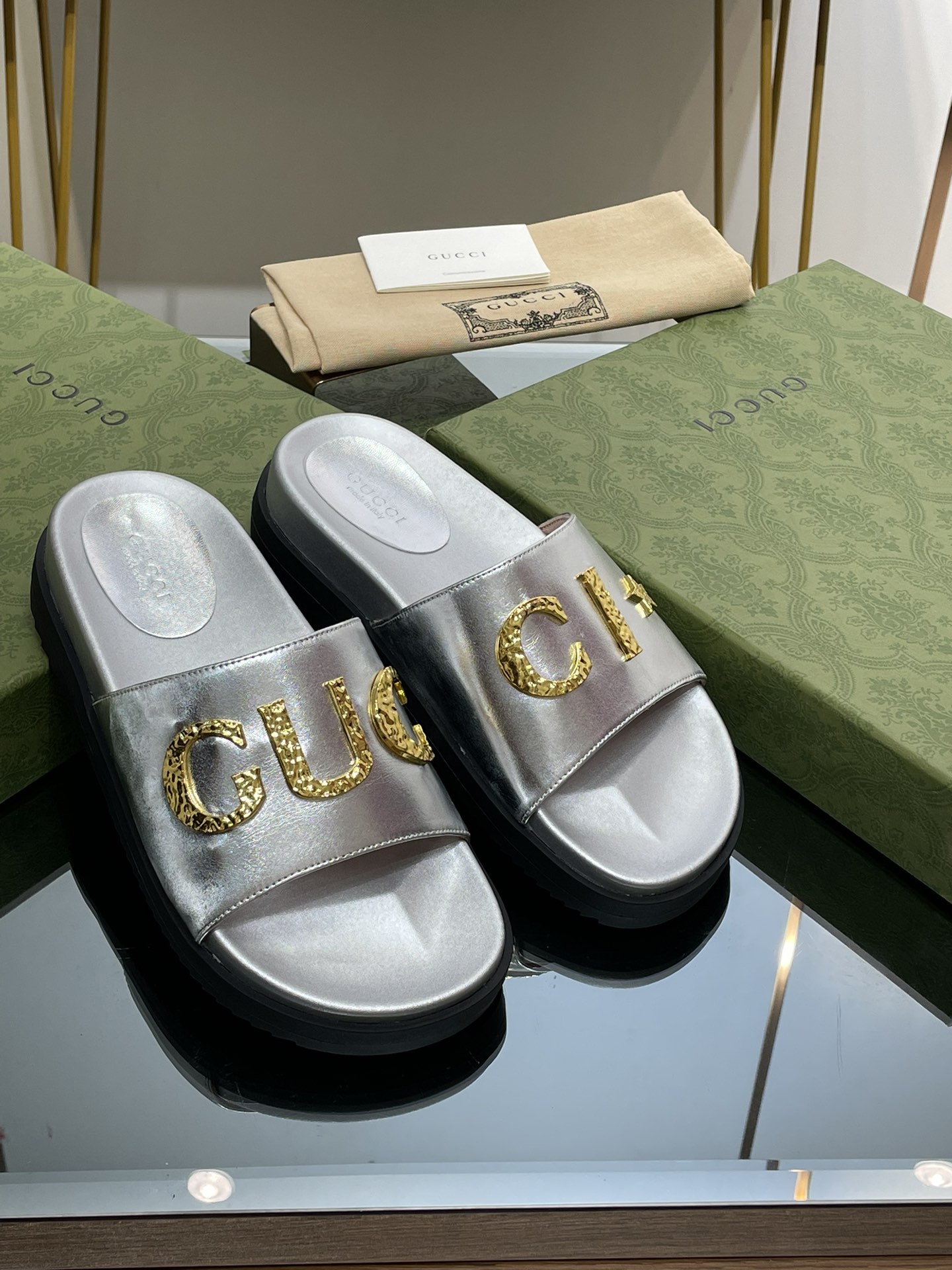 Gucci slippers with gold logo lettering buckle