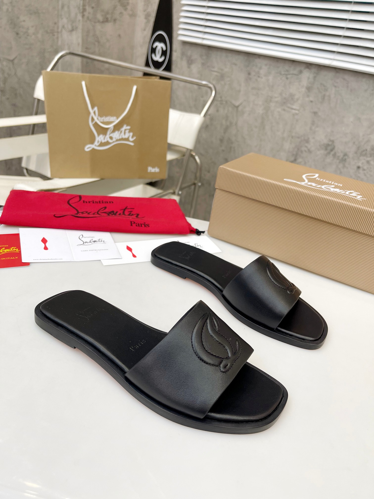 Christian Louboutin (CL) slippers with red soles