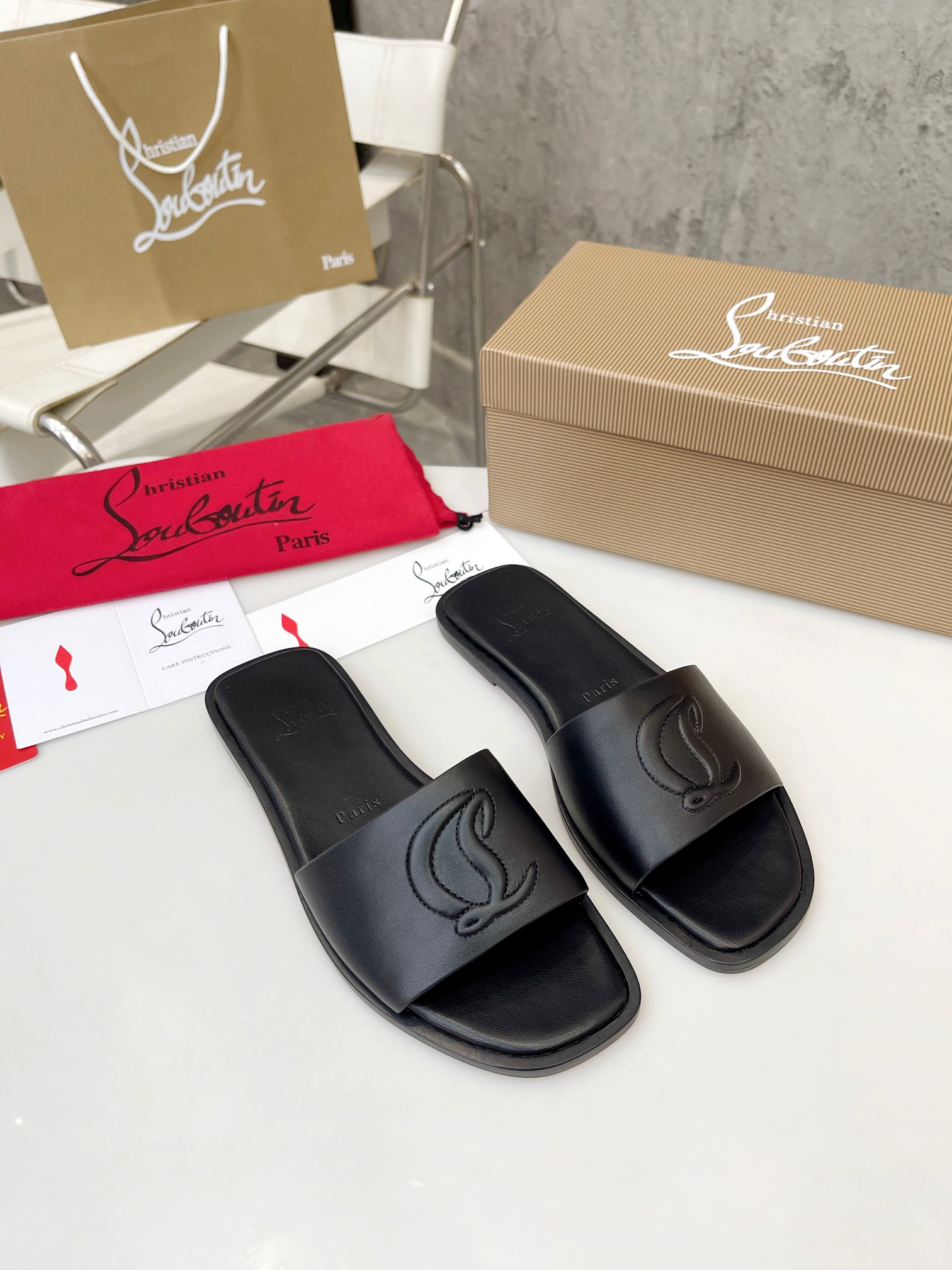 Christian Louboutin (CL) slippers with red soles
