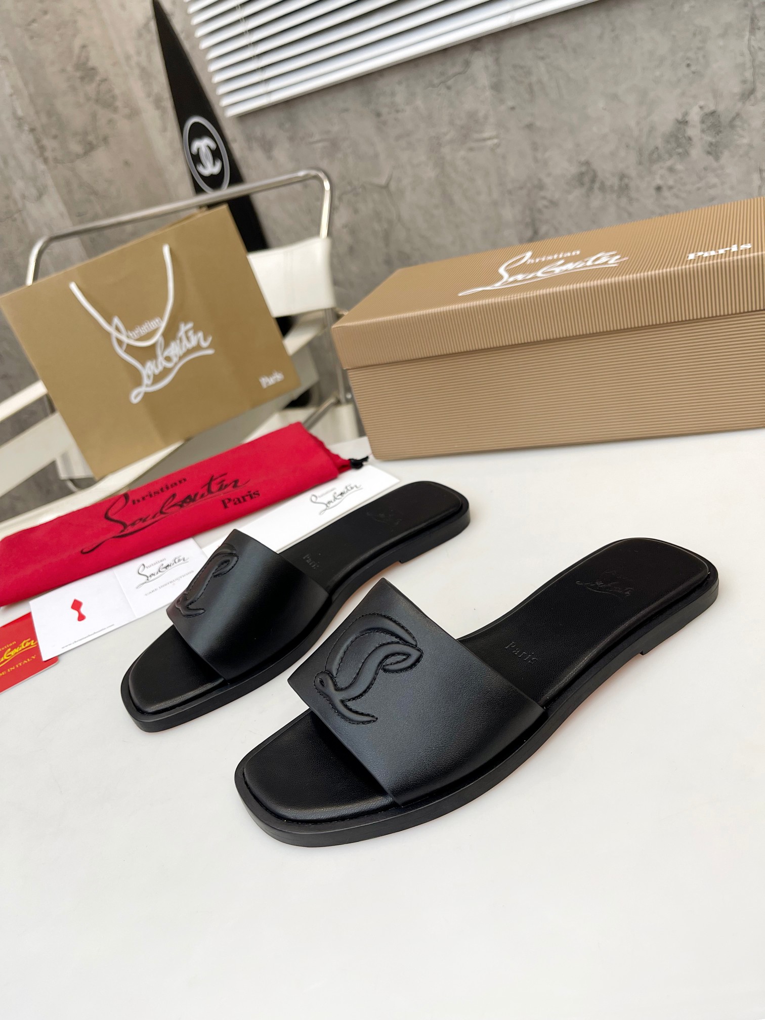 Christian Louboutin (CL) slippers with red soles