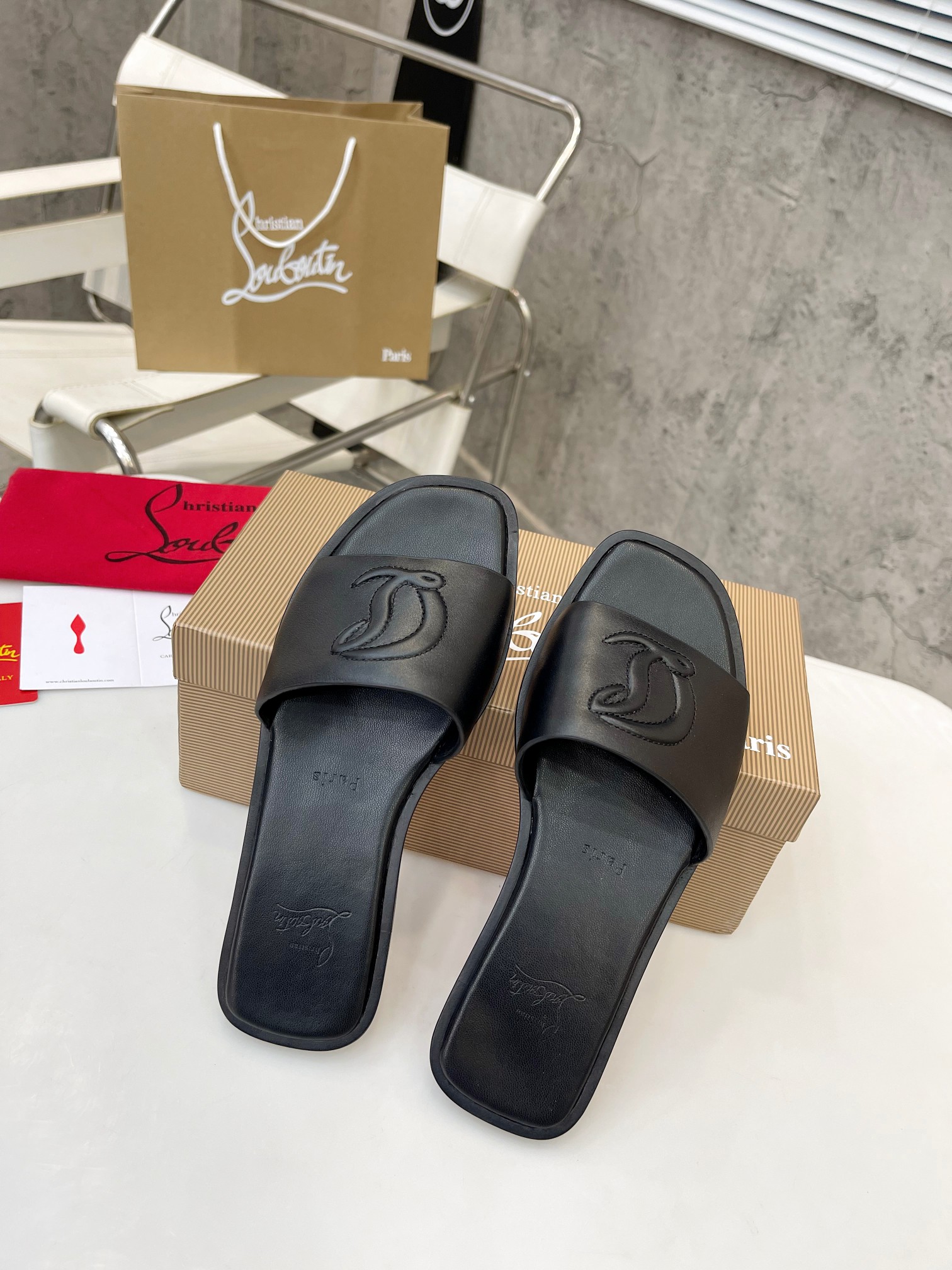 Christian Louboutin (CL) slippers with red soles